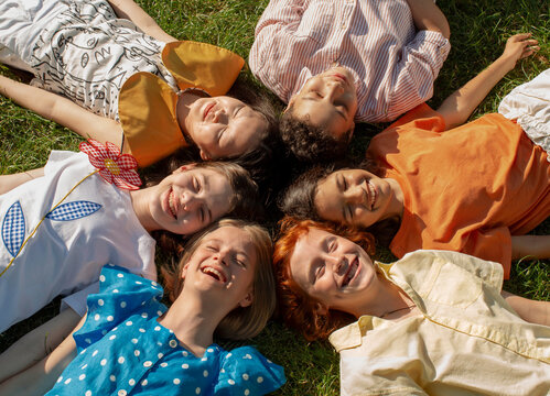 Six teenagers are lying on a grass.