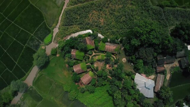 aerial view of an ecolodge on remote area with river and green vegetation