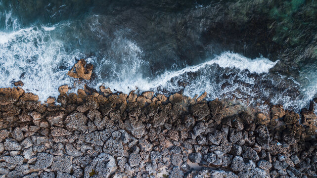 Ocean waves reach the rocks near the cliff