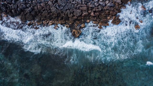 Ocean waves reach the rocks near the cliff