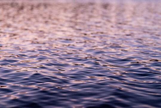 Specular sun glinting on water gently rippling on lake