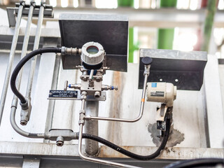 Temperature transmitter for measuring instrument close up in industry zone at power plant.