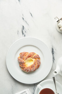 Sweet bun with cream served with tea