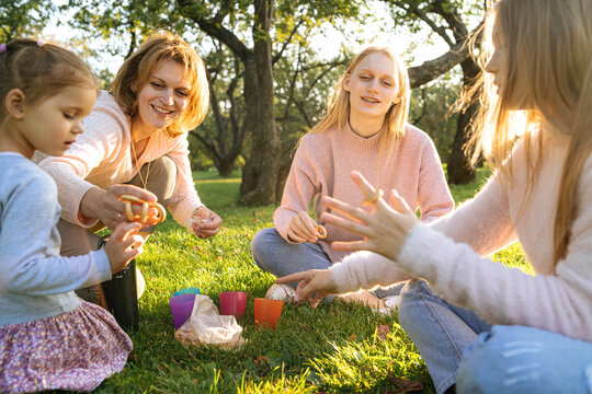 Mother sharing bread rings with daughters in park