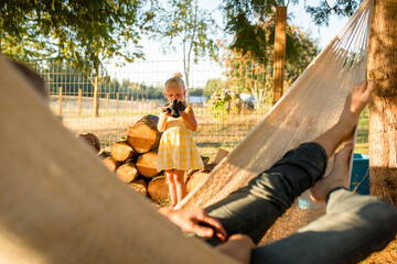 Young girl holds up camera outdoors