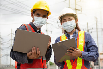Two Engineer teamwork wear face mask protect coronavirus covid19