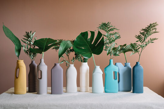 Composition of Colored Plastic Bottles Decorated with Leaves