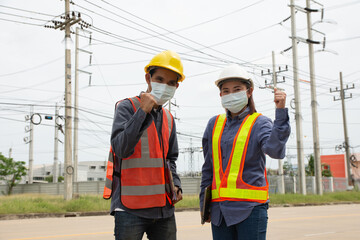 team of electrical engineers inspects the quality of the installation of high voltage poles