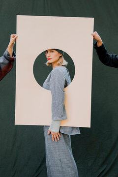Portrait of a woman framed by a cardboard shape