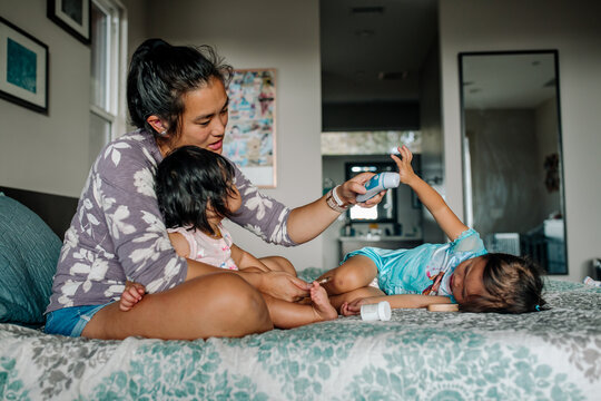 Caring deaf mom on bed with two sick girls