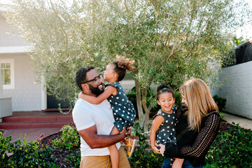 Happy biracial family outdoors with girls in matching outfits