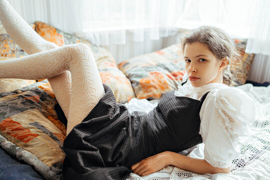 young woman lying on the bed looking at the camera