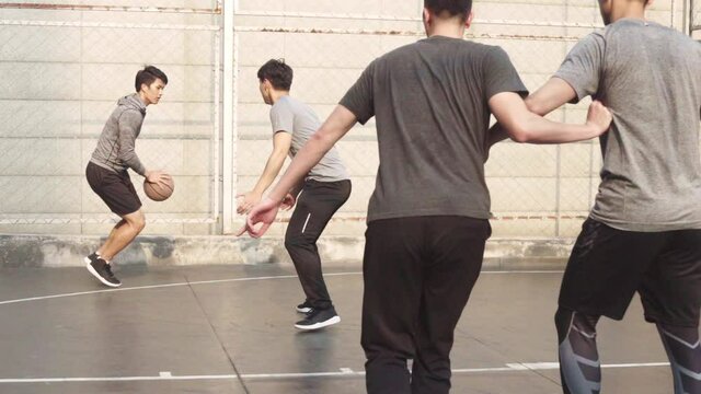 group of young asian men playing basketball for fun on outdoor court
