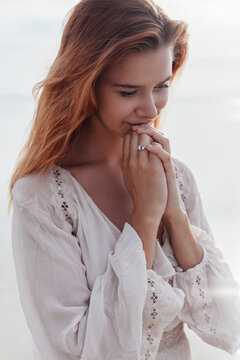 Young woman praying on beach