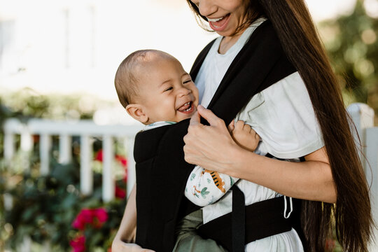 Happy Baby Carried By Mother