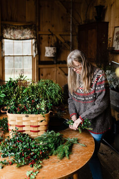 florist making holiday wreath  with holly