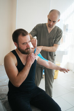 Doctor using kinesiotaping techniques on patient