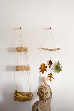 Toddler pointing at handmade decoration made out of waxed fall leaves
