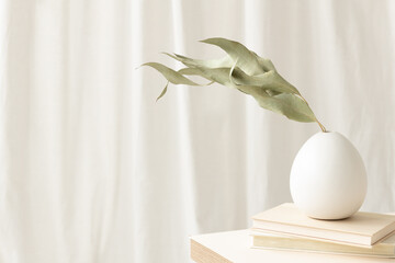 Green leaves in white vase