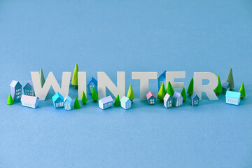 Winter. Miniature houses village over blue background,