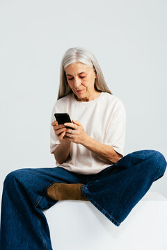 Trendy aged woman using smartphone