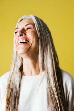 Cheerful senior female laughing with closed eyes