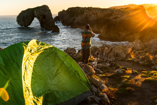 Photographer taking pictures in nature close to tent 