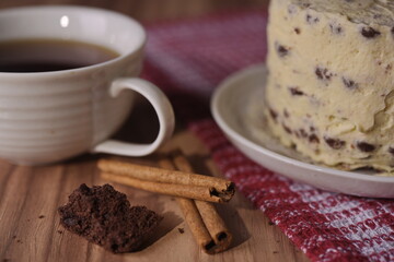 Cinnamon sticks, brownie slice cake, and a cup of coffee.