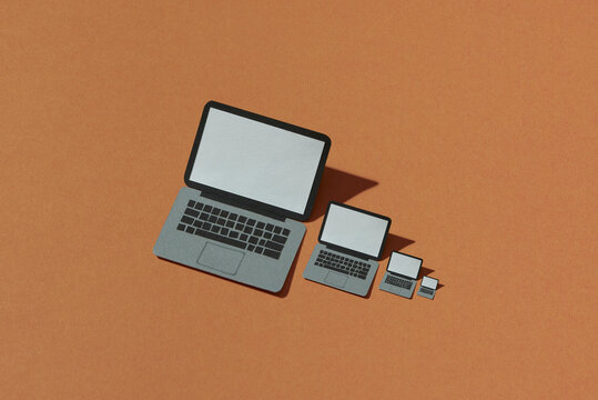 Laptop made by craft paper on brown background