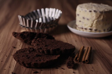 Brownie slices with buttercream and cinnamon sticks on the table.