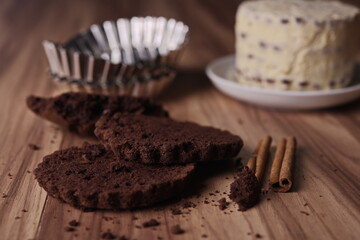 Brownie slices with buttercream and cinnamon sticks on the table.