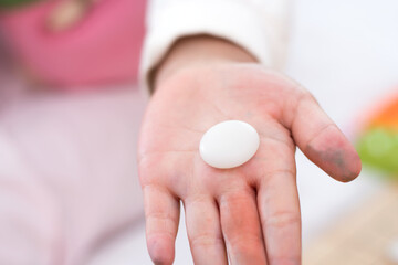 A white chess piece in the hands of a child