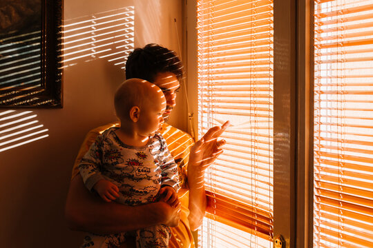 Father and baby boy by the window at morning sunshine.
