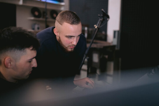 Boys writing and creating music together in recording studio 