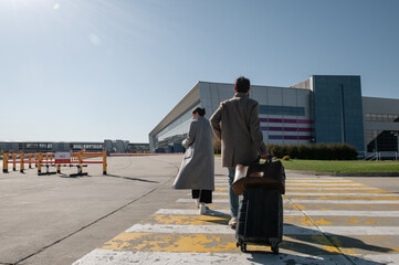 Anonymous couple walking towards airport building
