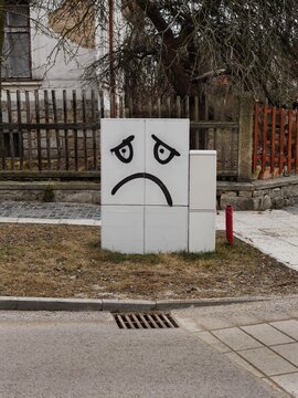 A powerbox painted with a sad face. 