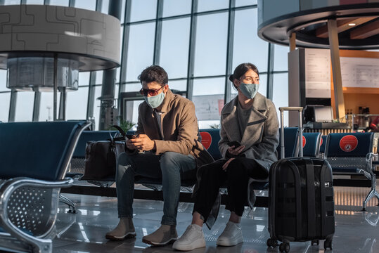 Couple in masks waiting for flight together