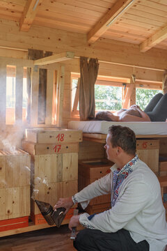 Beekeeper smoking bees during apitherapy session in wooden house