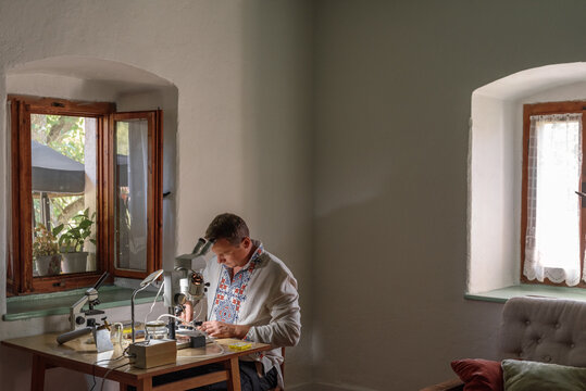 Male beekeeper preparing microscope at home
