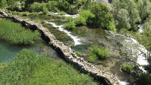 Girl Walking At Kudin Most (Kuda's Bridge) Over Krupa River In Golubic, Croatia. - aerial