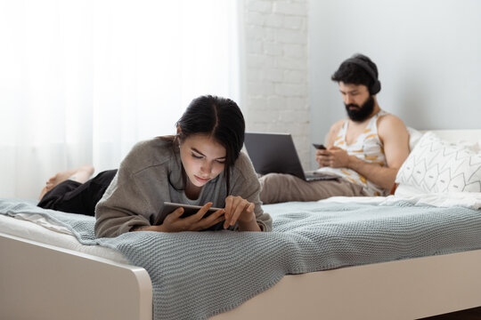 Young woman watching video on tablet near man