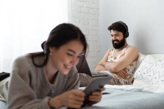 Cheerful man watching movie on laptop near girlfriend
