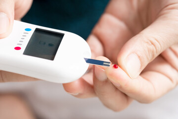 hand of people check diabetes and high blood glucose monitor with digital pressure gauge. Healthcare and Medical concept