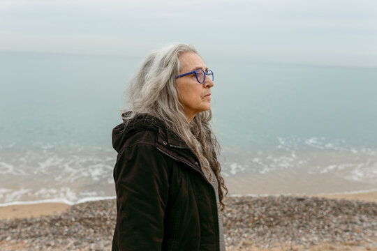 mature grey hair woman portrait by the sea