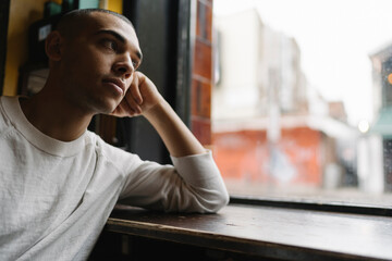 Young Man Using Computer Seated in a Coffee Shop