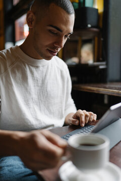 Man Drinking a Coffee and Working from a Coffee Shop