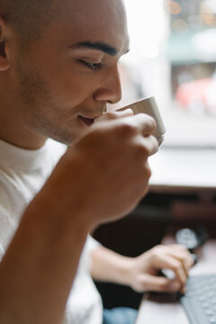 Man Drinking a Coffee and Working from a Coffee Shop