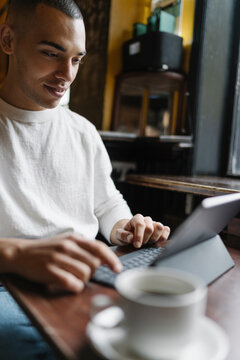 Man Drinking a Coffee and Working from a Coffee Shop