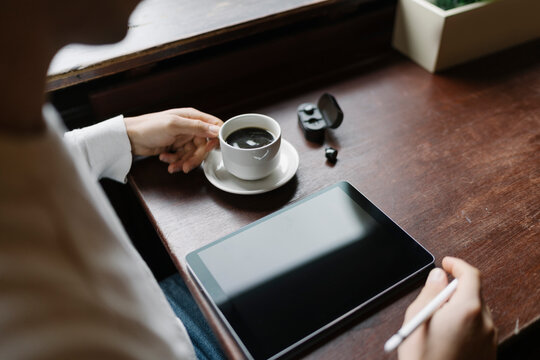 Man Drinking a Coffee and Working from a Coffee Shop