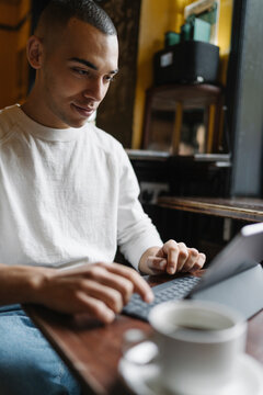 Man Drinking a Coffee and Working from a Coffee Shop